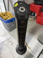 Full view of black tower heater standing on base