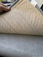 Underside of bath mat showing woven backing, tag and grey binding