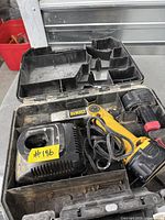 DeWalt cordless drill set inside molded case showing drill, two batteries, charger, case interior