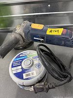 Angle grinder with handle, cord and container of cut-off discs