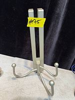 Front view of metal over-the-door hanger showing three hooks extended