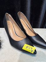 Side view of both black high heel shoes showing uppers and insoles