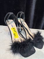 Both shoes angled to show overall style, toe fur trim, ankle straps and rhinestone heels