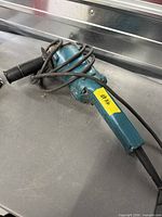 Full view of Makita 9005B angle grinder with cord and side handle