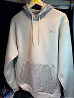 Front view showing hood, pocket, drawstrings, logo