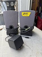 Front view of both Harman/Kardon computer speakers with attached cables and included AC adapter