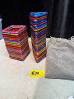 Stacks of multicolour magnetic square frames beside pouch