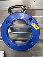 Front view of blue plastic fish tape reel showing handle and carabiner