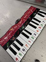 Full view of The Big Piano floor mat laid out on floor showing keyboard, numbers, instrument icons