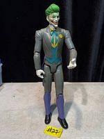 Front view of Joker 11.5-inch action figure in grey suit with green hair
