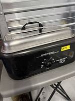 Front view showing Hamilton Beach branding, control dial, black body, stainless lid