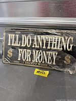 Sealed black and gold novelty license plate displaying full text and graphics