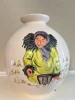 Front view of spherical vase showing painted woman and grassy scene