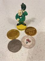 Group shot of figurine keychain with four casino tokens
