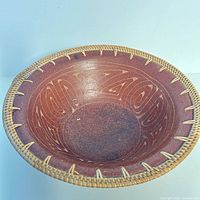 Top view of pottery bowl showing carved pattern and woven rim