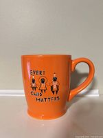Front of orange mug showing Every Child Matters graphic