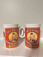Front view of both mugs showing graphics and handles