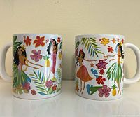 Front view of both mugs showing tropical graphics