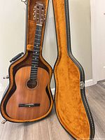 Guitar in open hard case showing interior lining and full instrument