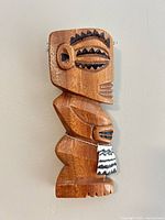 Front view of carved wooden tiki figure wall hanging