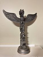 Front view of cast metal totem pole on base