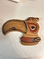 Front view of carved wood bird-head plaque