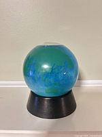 Front view of glitter earth globe on base
