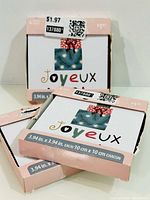 Three sealed coaster packs showing front graphics and size details