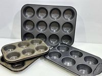 All four muffin pans arranged showing capacities and wear