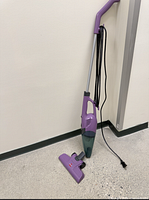 Vacuum assembled upright against wall showing full form and cord
