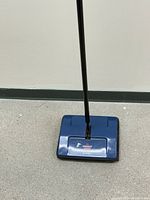 Top view of blue Bissell sweeper base with logo visible