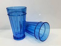 Two blue ribbed tumblers, one upright one on side