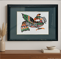 Framed bird art print displayed on wall with vase and bowl for scale