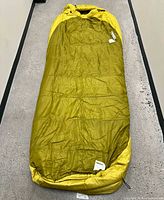 Full view of olive/yellow mummy sleeping bag
