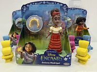Front view of Dolores Madrigal boxed figure with headband accessory, blue and yellow chairs visible