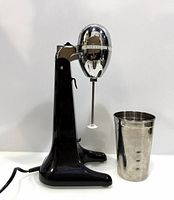 Full view of mixer with cup beside it