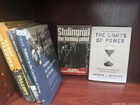 Front covers of five books on shelf