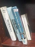 Spines of all four hardcover books on shelf