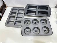 All three non-stick pans laid flat showing cavity layouts