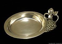 top view of oval metal serving dish showing grape cluster handle and interior