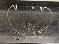 All three antique brass wire ornament stands on countertop