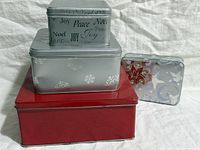 Four tins stacked showing sizes and designs