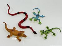 four toy reptiles laid out showing colours and forms