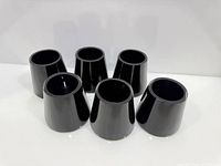 Six black glass tumblers grouped to show quantity and shape