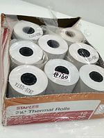 Open Staples box showing multiple 2 1/4" thermal paper rolls, some partially used