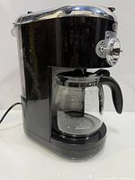 Left side view of black Sunbeam Heritage coffee maker with glass carafe attached