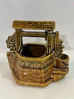 Front view showing wishing well form, planter opening, attached bucket