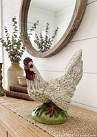 Full view of hen figurine on tabletop showing size, color and base