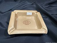 top view of square tan ceramic ashtray with Φ symbol