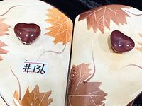 Top view of lids showing leaf motif and knob handles